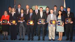 2011 PECASE winners holding their awards standing with DOE leadership on a stage (Ceremony: 8/1/12).